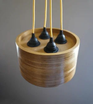 4 Bulb Round Pendant Light made of layered birch plywood with a smooth finish, suspended by a yellow fabric cable.